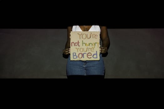 Woman holding cardboard sign with motivational message against overeating.