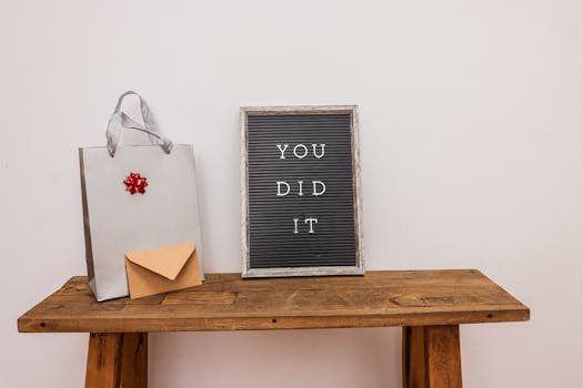 Gift bag with envelope and congratulatory letter board on wooden table.