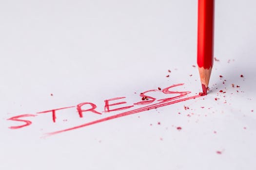 Close-up of a red pencil writing 'stress' on paper, symbolizing pressure and creativity.