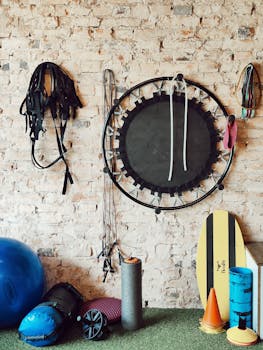 A diverse range of gym equipment arranged neatly against a rustic brick wall in a fitness studio.