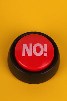 A bold red "No!" button set against a vivid yellow backdrop.