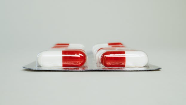 Blister pack of red and white capsules isolated against a simple background.
