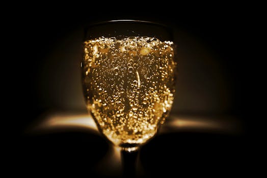 Elegant close-up of a champagne glass with bubbles against a dark background, perfect for celebrations.