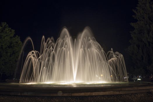 A mesmerizing fountain illuminated at night with elegant water jets creating a captivating display.