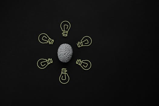 Conceptual photo of a brain surrounded by light bulb clips on black background.