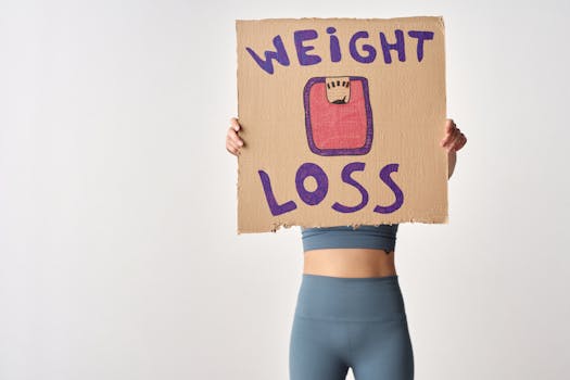 Person holding 'weight loss' sign for fitness motivation and health goals.