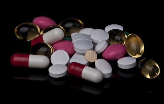 Close-up of various colorful pills and capsules on a black background.