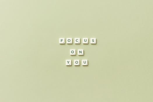 Scrabble tiles spell 'Focus on You' on a green background, promoting self-care.