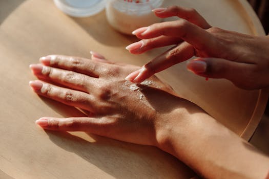 Hands applying moisturizing cream for healthy skin care treatment.