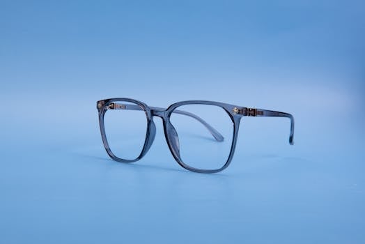 Classic eyeglasses on a blue background with minimalistic style.