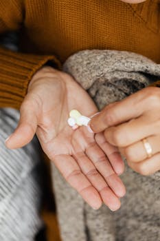 Close-up of a person's hands holding multiple pills, showcasing healthcare or medication theme.