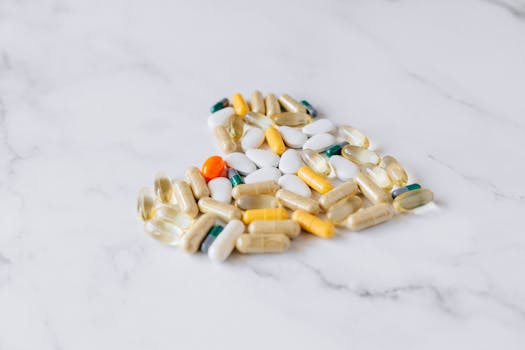 Close-up of various pills and supplements on a marble background, symbolizing health care and wellness.