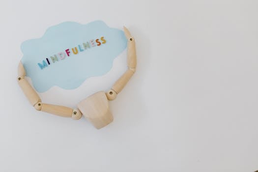 Wooden mannequin holding a mindfulness speech bubble for relaxation and mental health concepts.