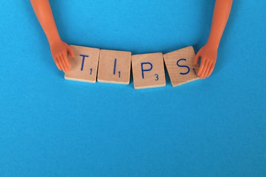 Scrabble tiles spelling 'TIPS' on a blue background, ideal for creative concepts.