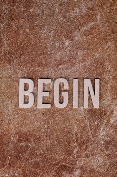 Inspirational 'Begin' text on brown marble surface, symbolizing fresh starts.