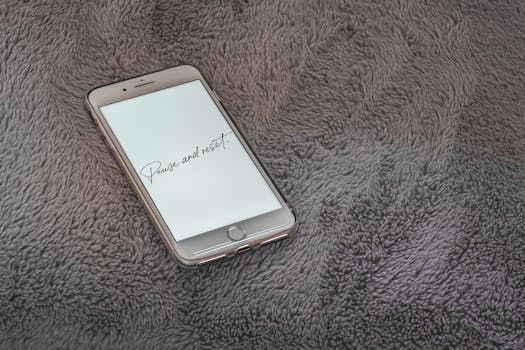 A smartphone displaying 'Pause and reset' message on a soft grey textured surface.