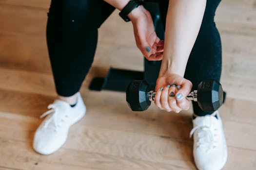 A woman working out with a dumbbell, emphasizing strength and fitness indoors.