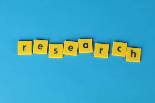 Yellow letter tiles spell the word 'research' on a vibrant blue surface, perfect for educational themes.