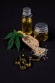 Cannabis oil, seeds, and capsules with a hemp leaf on a dark background.