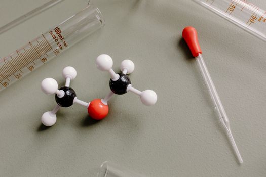 Close-up of laboratory equipment and molecular model on a flat surface.