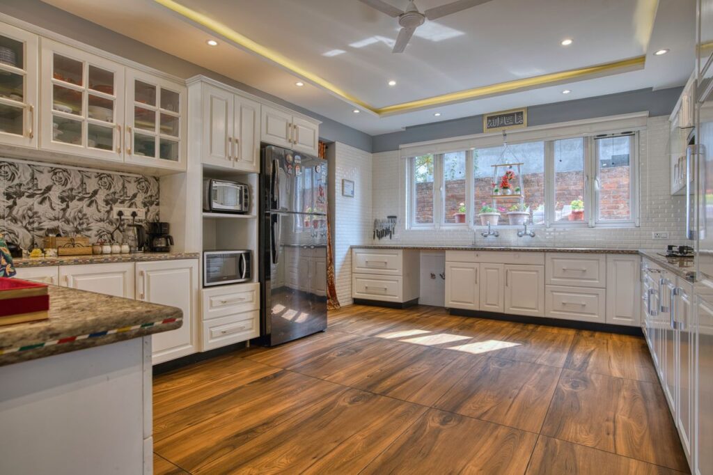 Bright and spacious modern kitchen with white cabinets in Jammu and Kashmir home.