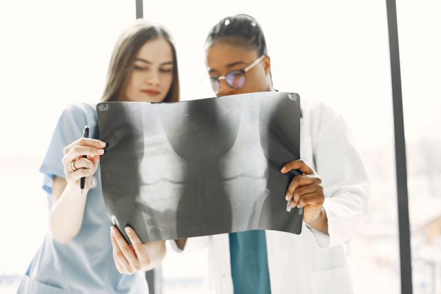 Two female doctors reviewing an x-ray image in a bright clinic.