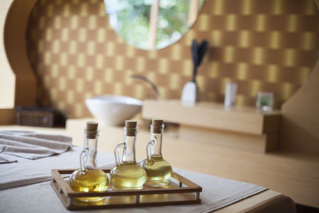 Elegant indoor spa room with natural oil bottles on a wooden tray.